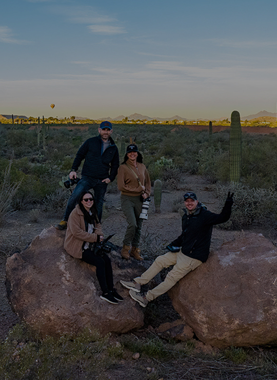 Kinetic Studios team sitting on rocks in the desert